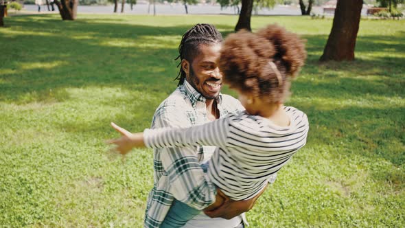 Close Portrait of a Darkskinned Family Father and Daughter Have Fun in the Park alt