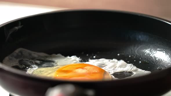 the Process of Making Scrambled Eggs From One Egg in a Black Frying Pan alt