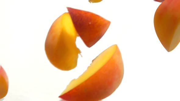 Peach Slices Fly Close-up on a White Background alt