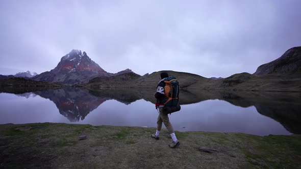 Pic du Midi d'Ossau, Lac d' Ayous (French Pyrenees). Man with huge backpack walking close the lake a alt