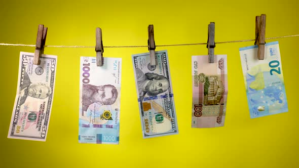 Banknotes of Different Countries Dry on a Clothespin Rope alt
