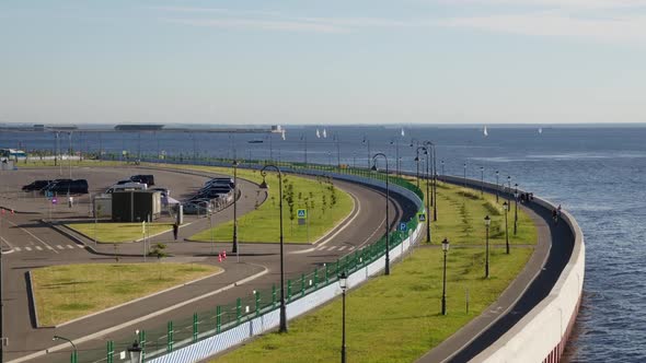seaside promenade with walking people, bike paths and green grass. alt