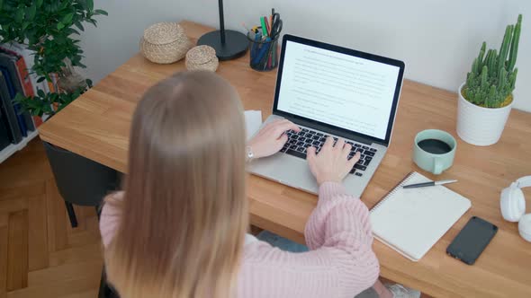 Woman Works in Home Office Using Laptop. Student or Copywriter Types Text
