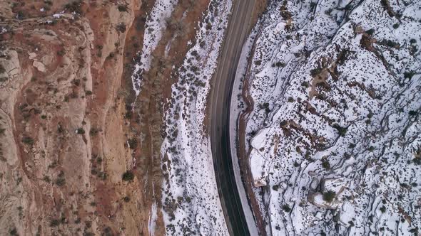 Aerial view looking down at car driving on road in the desert alt