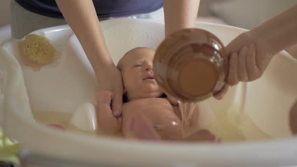 Mum and grandma bathing baby alt
