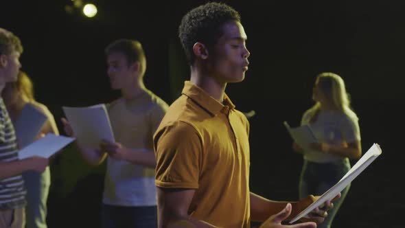 Students preparing before a high school performance in an empty school theater alt