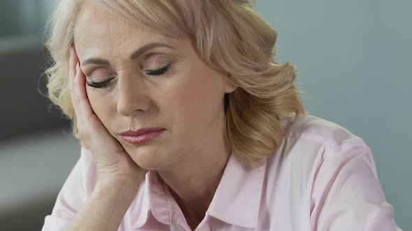 Overworked Mature Woman Sleeping at Workplace, Lack of Sleep and Vitamins alt