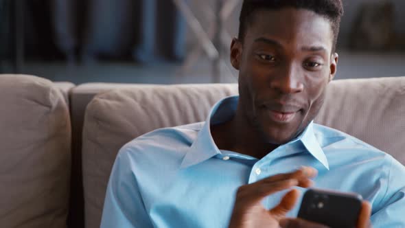 Young man talking with friend using smartphone video conference calling in virtual webcam alt