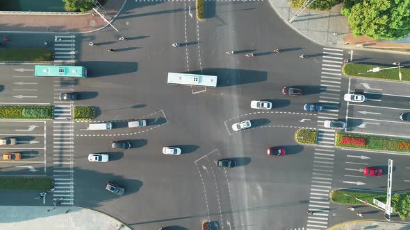 Aerial Drone Shot of Crossroad in the City, Cars and Buses Driving By Avenue. at Sunset. alt