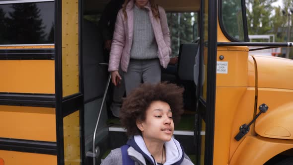 Multiethnic Pupils Going Down Steps of School Bus alt
