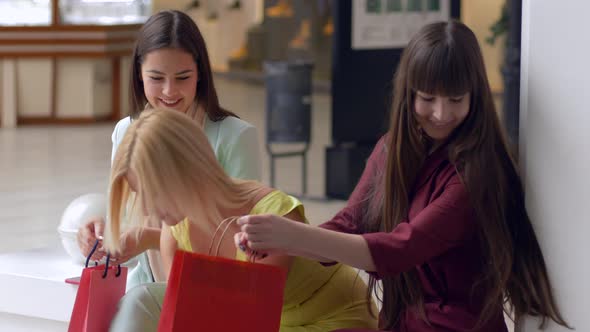 Happy Girlfriends Discuss New Purchases in Packages From Expensive Boutiques in Season of Sales and alt