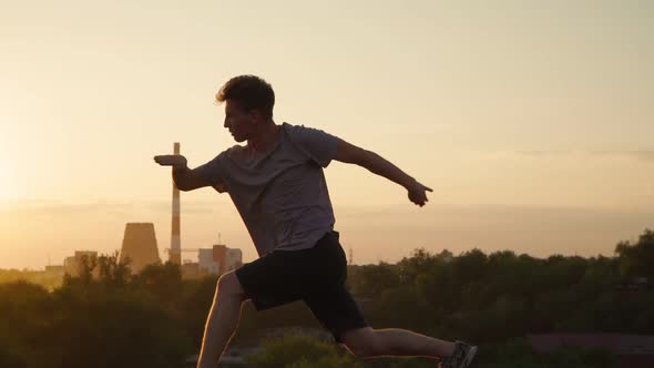 Silhouette of a man practicing martial arts on the background of a beautiful sunset. alt