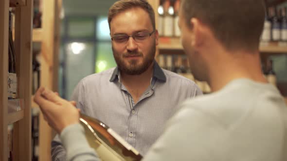 Customer Consults with the Wine Department Manager in the Liquor Store. The Wine Shop Manager alt