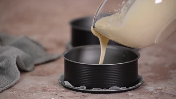 Pouring cake batter into cake molds.	