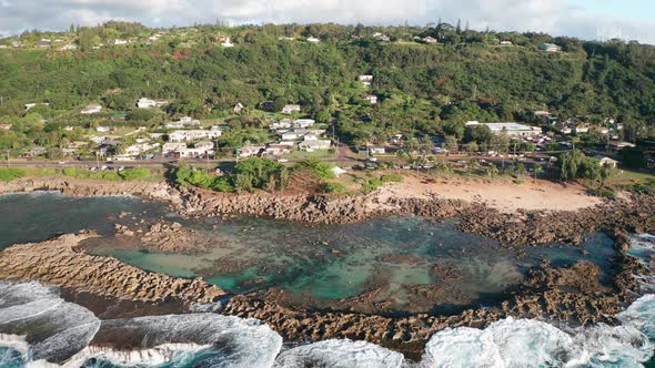 Panning aerial shot of above Shark Cove on O'ahu's rugged North Shore in Hawaii. 4K alt