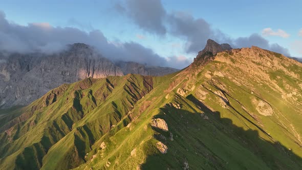 Dolomites mountains peaks with a hiking path on a summer sunrise alt