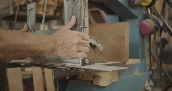 Carpenter pulls metal plate on a saw