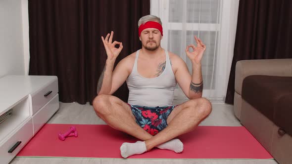 Retro Male Model Guy Calms Down Practicing Yoga Meditating at Home Sitting in Relaxing Lotus Pose alt