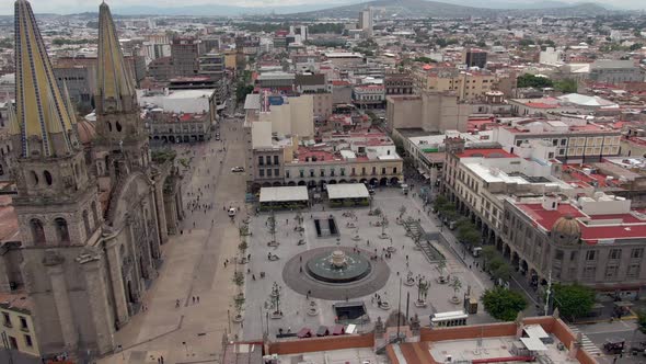 People Walking At Plaza Adjacent To Guadalajara Cathedral In Jalisco, Mexico. - forward aerial, tilt alt