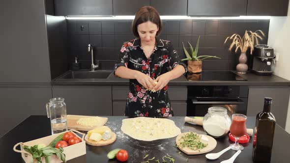 Cooking pizza at home. Woman making cheese pizza in domestic modern kitchen alt