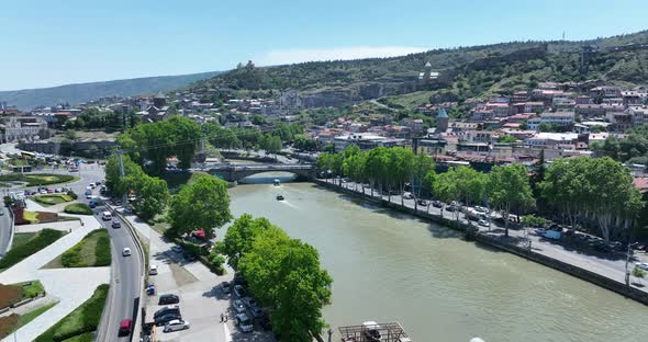Tbilisi, Georgia - June 7 2022: Flying over  kura river in the center of Tbilisi city alt