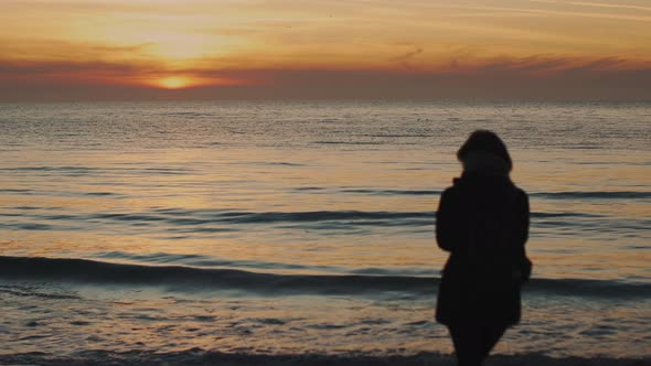 Silhouette of a Young Woman on a Background of the Sea alt
