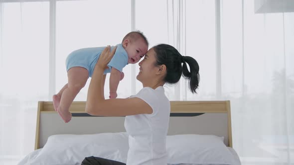 Seraph102020 263Family concept. Mother playing with baby in the bedroom. 4k Resolution. alt