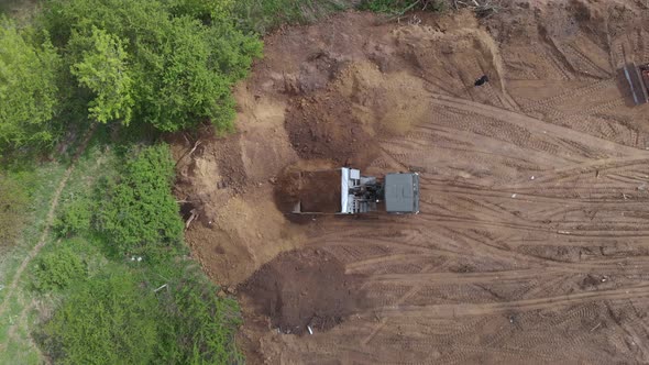 Top aerial shot: tipper pouring out soil on place preparing for construction residential house.
