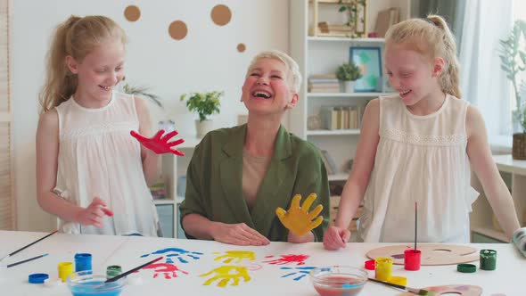 Grandma and Kids Making Handprints alt