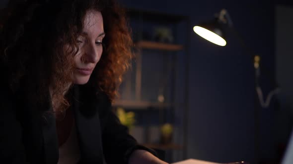 Sad Tired Depressed Business Woman Sitting at Her Desk in the Office Late at Night alt