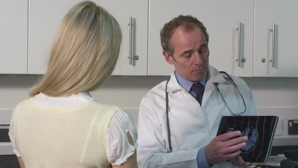 MS Male doctor using tablet and discussing with patient in hospital / London, United Kingdom