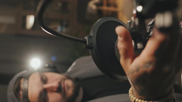 Vertical Slowmo of Man Starting His Podcast alt