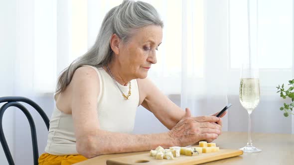 Beautiful Old Grandmother with Grey Hair and Face with Wrinkles is Using Smartphone Talking with alt