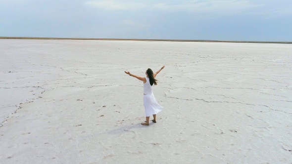 Girl standing on a dry salt lake and meditates