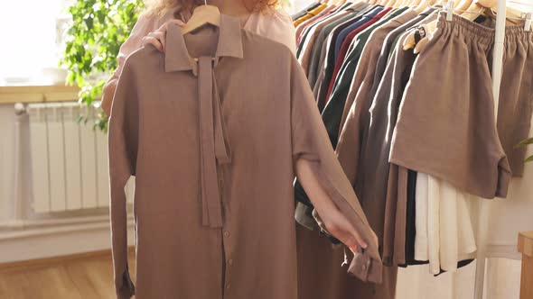 Caucasian Young Woman in an Ecological Shop Standing By Rack with Syntheticfree Clothes