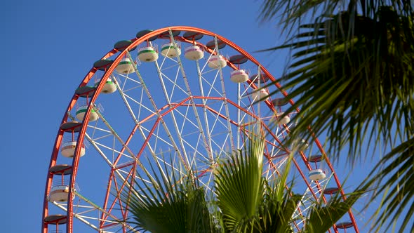 Amusement Park Ferris Wheel Slowly Turning Against Blue Sky alt