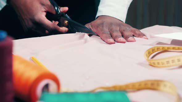 Fabric is Getting Cut Into Halves By a Tailor alt