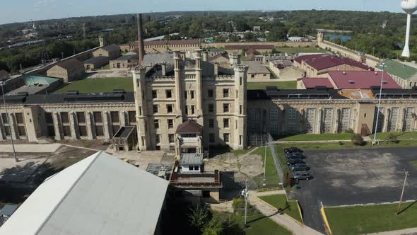 Aerial view of the derelict and abandoned Joliet prison or jail, a historic place. Droneing towards alt