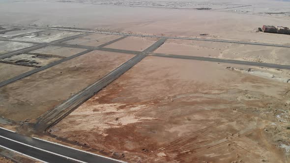 Flight over the desert in Egypt. Cars are driving far away alt