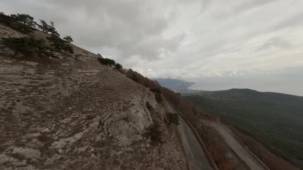 Aerial Shooting From Sports High Speed Fpv Drone White Suv Car Driving on Natural Serpentine Road alt