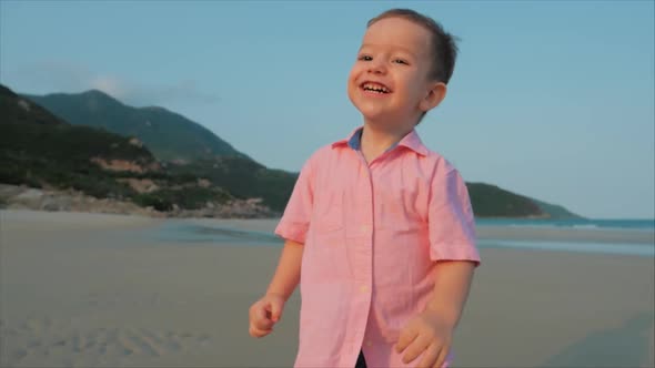 Happy Kid Running Along the beach.Silhouette of Children's Feet Walking on Wet Sand alt