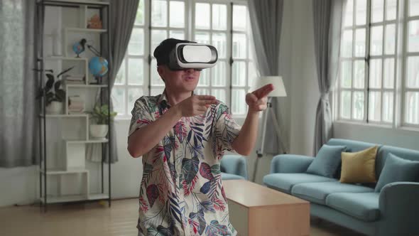 Asian Man Playing Game In Virtual Reality At Home alt