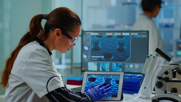 Scientist Using Digital Tablet Analysing Virus Evolution alt