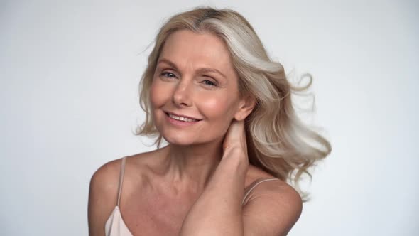 Happy 50s Middle Aged Mature Woman with Flying Blond Hair Looking at Camera alt