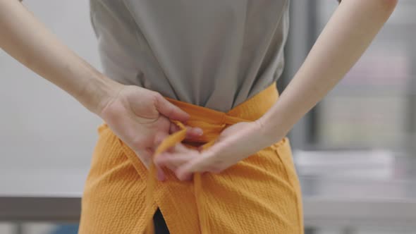 A Bright Young Pastry Chef Girl Puts on a Work Uniform