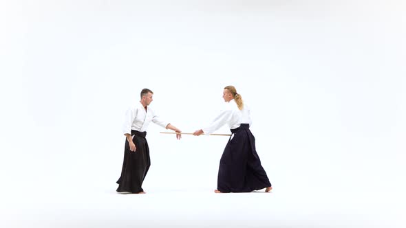 Athletes in Kimono Demonstrating Aikido Using Bokken. Isolated on White. alt