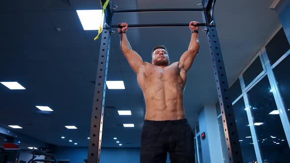 Shirtless man pulling up on horizontal bar. Crossfit athlete doing abs  exercises on horizontal bar, Stock Footage