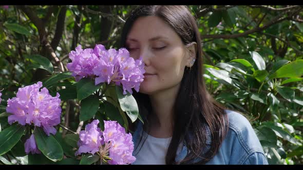 Female Smelling Lilac Flowers in the Garden