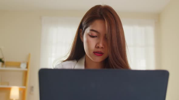 Asia women casual wear using laptop working in living room at home. alt