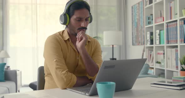 Man connecting with his laptop and wearing headphones